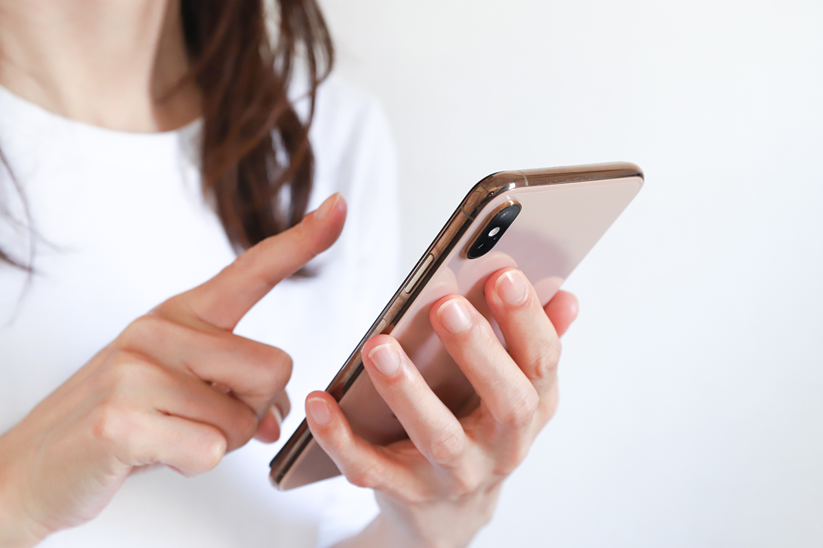 スマートフォンを操作する女性の手元